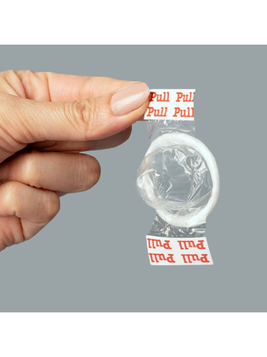 Mano sujetando un preservativo Uniq Pull transparente por las dos tiras marcadas Pull